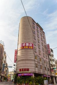 un edificio alto con dei cartelli sul lato di Good Hotel a Fengyuan