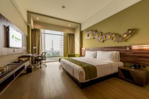 um quarto de hotel com uma cama e uma televisão em Holiday Inn Cikarang Jababeka, an IHG Hotel em Cikarang