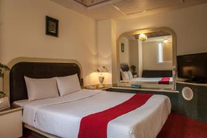ein Hotelzimmer mit einem großen Bett und einem Spiegel in der Unterkunft 真正好旅店 Good Hotel in Fengyuan
