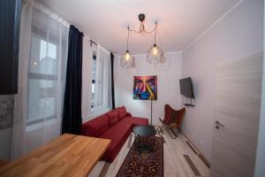 a living room with a red couch and a table at Heights Accommodation City Center in Bucharest