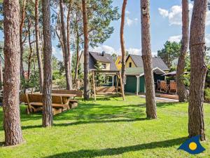 a house with a yard with trees at Fraeulein Loddin Whg_ Hugo in Kölpinsee