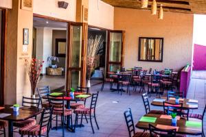 een restaurant met tafels en stoelen in een kamer bij Coyotes Hotel & Conference Centre in Nelspruit