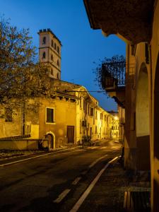 an old building with a clock tower on a street at Camera Rustica in Valpolicella con parcheggio in Pescantina