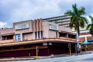 a building with a palm tree in front of it at Coyotes Hotel & Conference Centre in Nelspruit