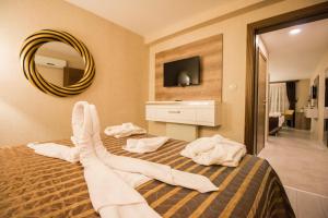 a hotel room with a bed with white towels on it at Hotel Business Han in Nevşehir