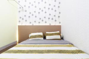 uma cama com duas almofadas num quarto em Krisna Hostel em Medan