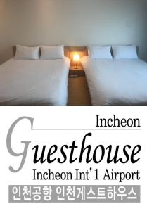 two beds sitting next to each other in a room at Incheon Airport Guesthouse in Incheon