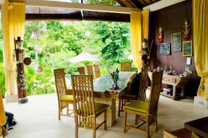 a dining room with a table and chairs at Minabali Bunga'lo in Tulamben