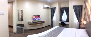 a hotel room with a bed and a tv at D'Village Resort Melaka in Melaka