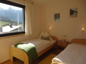 アプテナウにあるFerienwohnung Ronacherのベッドが2つと大きな窓がある寝室