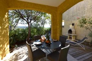a patio with a table and chairs on a deck at Résidence Chiar' Di Luna in Sainte-Lucie de Porto-Vecchio