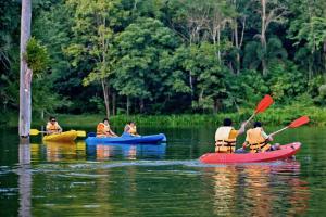 eine Gruppe von Menschen in Kajaks auf einem Fluss in der Unterkunft Home Phutoey River Kwai Hotspring & Nature Resort - SHA Extra Plus in Sai Yok