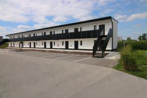 a large white building with a staircase in a parking lot at NU Hotel by WMM Hotels in Neu-Ulm