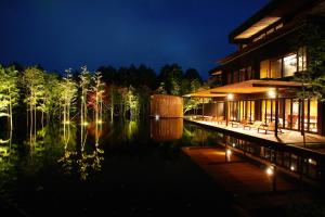 um edifício ao lado de um lago à noite em Kinnotake Sengokuhara(Adult Only) em Hakone