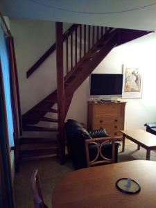 un soggiorno con scala e televisore di apartmán Tuckin a Rokytnice nad Jizerou