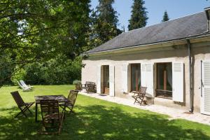 une maison blanche avec une table et des chaises dans la cour dans l'établissement La Barillerie, à La Flèche