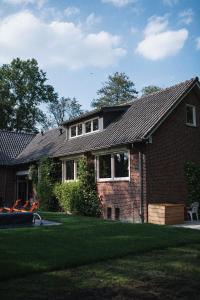 a brick house with a shingled roof at The Annex Retreat - a luxury countryside villa in Geijsteren +45 photos