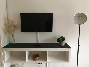 una TV a schermo piatto su un centro di intrattenimento bianco di Appartement Hochkönigreich a Saalfelden am Steinernen Meer