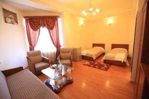 Sala de estar con 2 camas y mesa en Jermuk Ani Hotel, en Jermuk