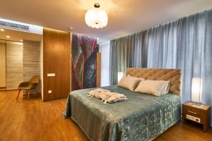 a bedroom with a bed with a blue bedspread at Light Hotel in Dnipro