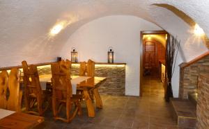 a dining room with a table and wooden chairs at Restaurace a penzion pod hradem in Zlín