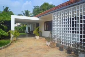 a white house with potted plants in front of it at Jaffna Heritage Villa in Jaffna