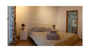 1 dormitorio con 1 cama con toallas en APTO EDU 3MIN DE LA PLAYA, en Fuengirola