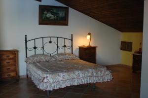 Un dormitorio con una cama y una lámpara. en El Romerito en Zalamea la Real
