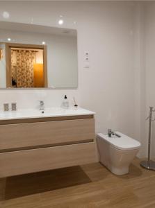 a bathroom with a sink and a toilet and a mirror at APTO EDU 3MIN DE LA PLAYA in Fuengirola