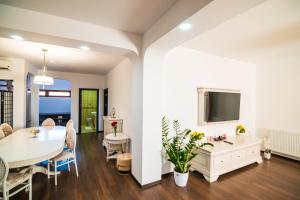 a living room with a white table and a tv at Residence Riverside in Galaţi
