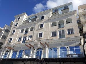 a large white building with many windows at Plava Vila Beach Apartments Sveti Stefan in Sveti Stefan