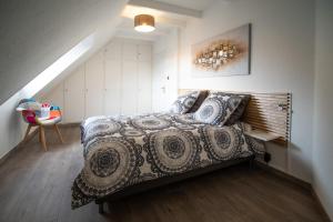 ein Schlafzimmer mit einem Bett in einem Zimmer im Dachgeschoss in der Unterkunft Le rohan sawadee in Colmar