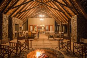 una sala de estar con una hoguera en el centro de un edificio en Ntamba Safari Lodge en Matlhagame