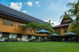 a building with chairs and umbrellas in front of it at Arsela Hotel Pangkalan Bun in Pangkalan Bun