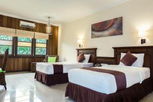two beds in a hotel room with two beds at Arsela Hotel Pangkalan Bun in Pangkalan Bun