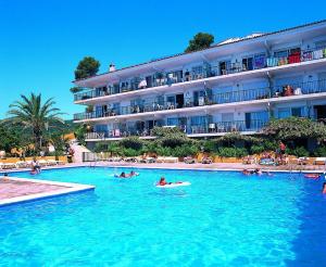 a group of people in a swimming pool in a hotel at Apartamentos Cala Llevado in Tossa de Mar