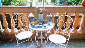 stół z talerzem jedzenia i 2 krzesłami w obiekcie Tilia w Bolonii