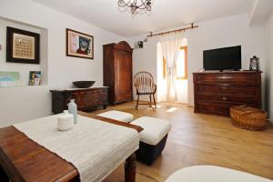uma sala de estar com uma mesa e uma televisão em Apartment Fantov Old Town Residence em Baska