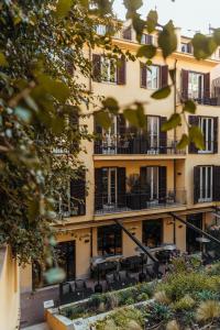 a building with tables and chairs in front of it at Margutta 19 - Small Luxury Hotels of the World in Rome