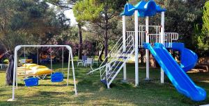 einen Spielplatz mit einer blauen Rutsche und einer Rutsche in der Unterkunft Palm Beach Hotel in Küçükkuyu