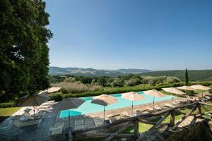 ein großer Pool mit Sonnenschirmen und Stühlen in der Unterkunft Il Defizio in Gambassi Terme