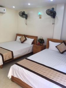 twee bedden in een hotelkamer met twee bedden bij Minh Đức hotel in Cat Ba