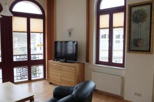 a living room with a tv and two windows at Haus Lucie in Heringsdorf