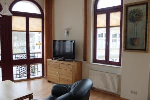 ein Wohnzimmer mit einem TV und 2 Fenstern in der Unterkunft Haus Lucie in Heringsdorf