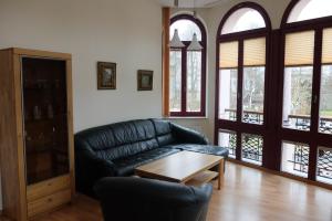 een woonkamer met een leren bank en een tafel bij Haus Lucie in Heringsdorf