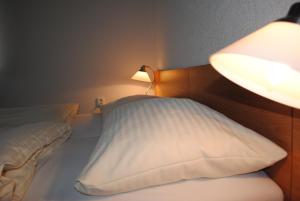 een slaapkamer met een bed met een lamp en een kussen bij Hotel Allvet in Drnovice