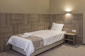 a bedroom with a large bed with white sheets at Семеен Хотел Естило in Dimitrovgrad