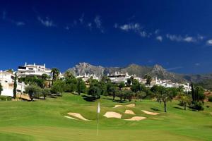 vista su un campo da golf con montagne sullo sfondo di Cozy Apartament in Golden Mile a Marbella