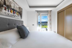 a bedroom with a white bed and a window at Apartment front Line La Cala Golf Resort in La Cala de Mijas