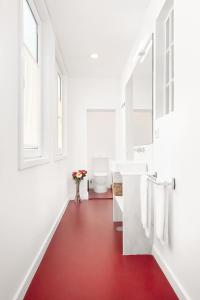 een badkamer met een rode vloer en een witte wastafel bij Host Wise - Oporto Classic Apartment in Porto